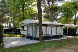 ein Zelt neben einem Baum in der Unterkunft PS-Caravaning auf Union Lido - Wohnwagenvermietung in Cavallino-Treporti