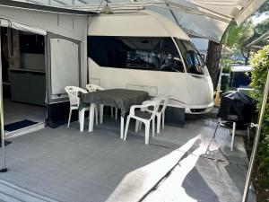 un tavolo e sedie di fronte a un furgone bianco di PS-Caravaning auf Union Lido - Wohnwagenvermietung a Cavallino-Treporti