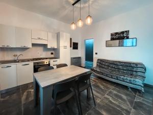 uma cozinha com armários brancos e uma mesa e cadeiras em app arena em Reggio Emilia
