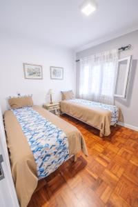 2 letti in una camera con pavimenti in legno di Casa Maravilha II a Caniço