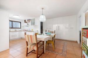 a kitchen and dining room with a table and chairs at Villa Floti con vistas al mar in Telde