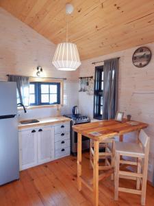 eine Küche mit einem Holztisch und einem Kühlschrank in der Unterkunft Ocean Paradise 1 in Punta Del Diablo