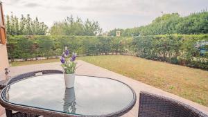 uma mesa com um vaso de flores em cima em Villa Corte Barcuzzi - Italian Homing em Barcuzzi