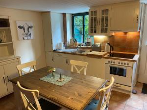 a kitchen with a wooden table and a table and chairs at Ferienhaus Mangels in Steinau