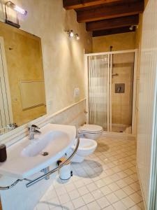 a bathroom with a sink and a toilet and a mirror at Vittoria al Castello in Pozzolengo