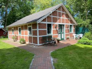 a small brick house with a picnic table in a yard at Ferienhaus Mangels in Steinau