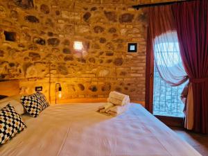 a bedroom with a large bed in a stone wall at Vittoria al Castello in Pozzolengo