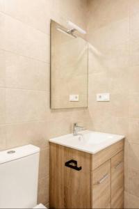 uma casa de banho com um lavatório, um WC e um espelho. em Blue Sky Apartment em Torremolinos