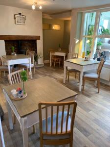 uma sala de jantar com mesas e cadeiras e uma lareira em No 3 em Penrith