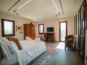 een slaapkamer met een wit bed en een televisie bij Foresteria Castello di Perno in Monforte dʼAlba