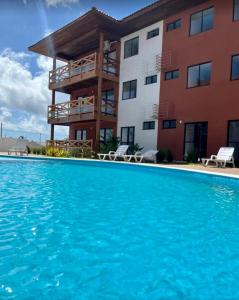 um hotel com piscina em frente a um edifício em Vila Atlantida em Luís Correia