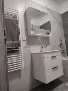 a white bathroom with a sink and a mirror at APARTMÁN ČAMBOR - na skok do prírody a mesta in Stupava +24 photos