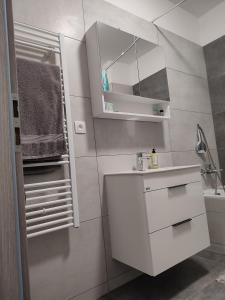 a white bathroom with a sink and a mirror at APARTMÁN ČAMBOR - na skok do prírody a mesta in Stupava