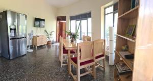 a kitchen with a table and chairs and a refrigerator at Nile Retreat in Jinja