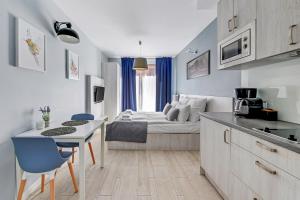a kitchen and living room with a bed in the background at Downtown Apartments Riverside Aura Island in Gdańsk