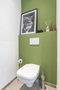 een badkamer met een wit toilet in een groene muur bij Hike & Bike Home in Heusden - Zolder
