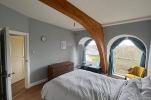 a bedroom with two arched windows and a bed at Peaceful bright city hide away with parking in London
