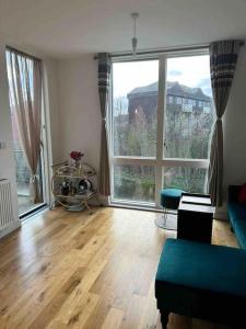 a living room with a hard wood floor and large windows at Sunny 1bedroom flat for rent. in London