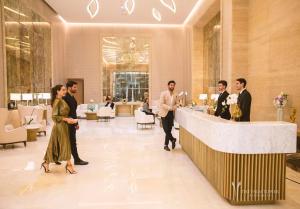 een groep mensen die door een lobby lopen bij Ultra Luxury Palm Tower with Shared 5 Star Hotel Facilities in Dubai