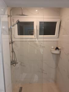 a bathroom with a shower with a glass door at White Tower Apartment in Thessaloniki