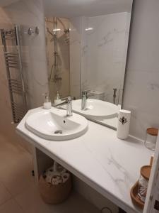 bagno bianco con lavandino e specchio di White Tower Apartment a Salonicco