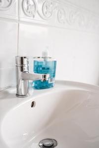 ein Waschbecken mit einem Wasserhahn und einer blauen Flasche darauf in der Unterkunft Home Away From Home in Sheffield