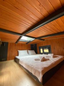a large bed in a room with a wooden ceiling at Golifehouses in Arnavutköy
