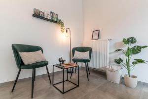 twee groene stoelen en een tafel in een kamer met planten bij Hike & Bike Home in Heusden - Zolder