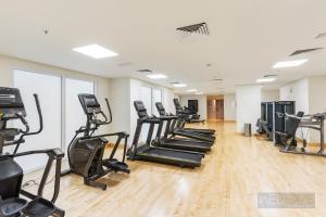 a gym with treadmills and elliptical machines at WelHome - Apt Close to Yas Waterworld and Ferrari Circuits in Abu Dhabi