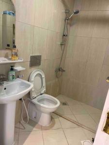 een badkamer met een douche, een toilet en een wastafel bij deluxe apartment closed to beach in Sharjah