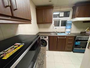 a small kitchen with a stove and a dishwasher at deluxe apartment closed to beach in Sharjah