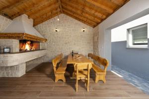 a dining room with a table and a fireplace at Modern villa Danica with pool in Zadar in Bibinje