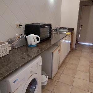 a kitchen with a microwave and a washing machine at Altos H in Santiago del Estero