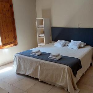 a bedroom with a large bed with towels on it at Altos H in Santiago del Estero