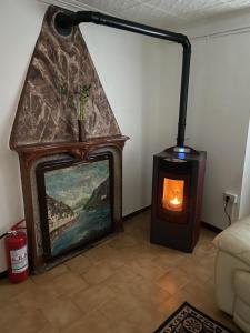 a living room with a fireplace and a painting at Cà Rosina Casavacanze in Brusimpiano