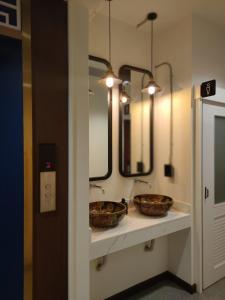 zwei Körbe auf einer Theke in einem Badezimmer mit zwei Spiegeln in der Unterkunft N5 Ratchawong Hostel in Samphanthawong