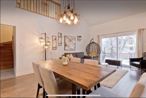 uma sala de jantar e sala de estar com uma mesa de madeira em Cap Magog ! Près du lac Memphrémagog et Mont Orford em Magog-Orford