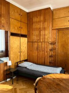- une chambre avec des murs en bois, un lit et une table dans l'établissement Room in Old Town Krakow, à Cracovie