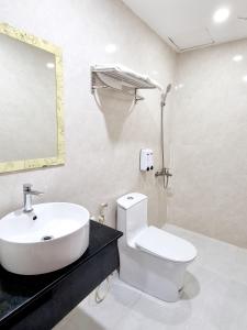 uma casa de banho com um lavatório, um WC e um espelho. em Minh Khue Hotel em Vinh Long