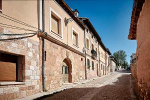 an empty alley with a stone building on a street at HESTIA VuT in Ayllón