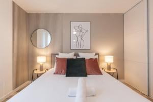 a bedroom with a large white bed with two lamps at *New* Céleste Appart 6 Pax 5 min Disney in Serris