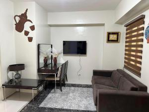- un salon avec un canapé et une télévision dans l'établissement Supreme Condo at Brenthill Baguio, à Baguio