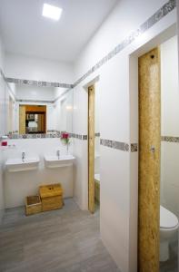 La salle de bains est pourvue de 2 lavabos et de toilettes. dans l'établissement Italica Hostel, à Santiponce