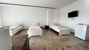 Dieses weiße Zimmer verfügt über 2 Betten und einen TV. in der Unterkunft Pension MC City in Gaimersheim