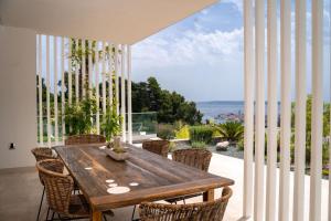 a dining room with a wooden table and chairs at Luxury villa Mar with infinity pool in Rab in Palit