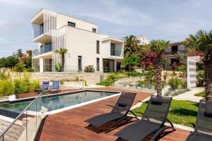 a villa with a swimming pool and a house at Luxury villa Mar with infinity pool in Rab in Palit