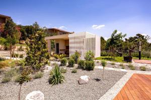a garden with plants in front of a house at Luxury villa Mar with infinity pool in Rab in Palit