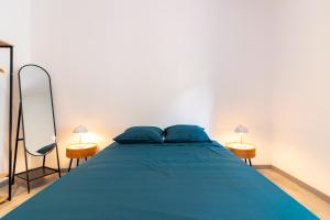 una camera con un letto blu con due lampade di Appartement moderne et élégant quartier Saint-Jean Perpignan 2 a Perpignano