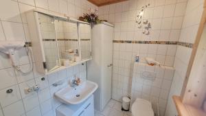 a white bathroom with a sink and a shower at Ferienhaus-Burg in Celle
