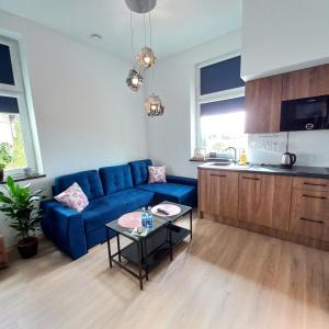 a living room with a blue couch and a table at Apartament w Tucholi in Tuchola